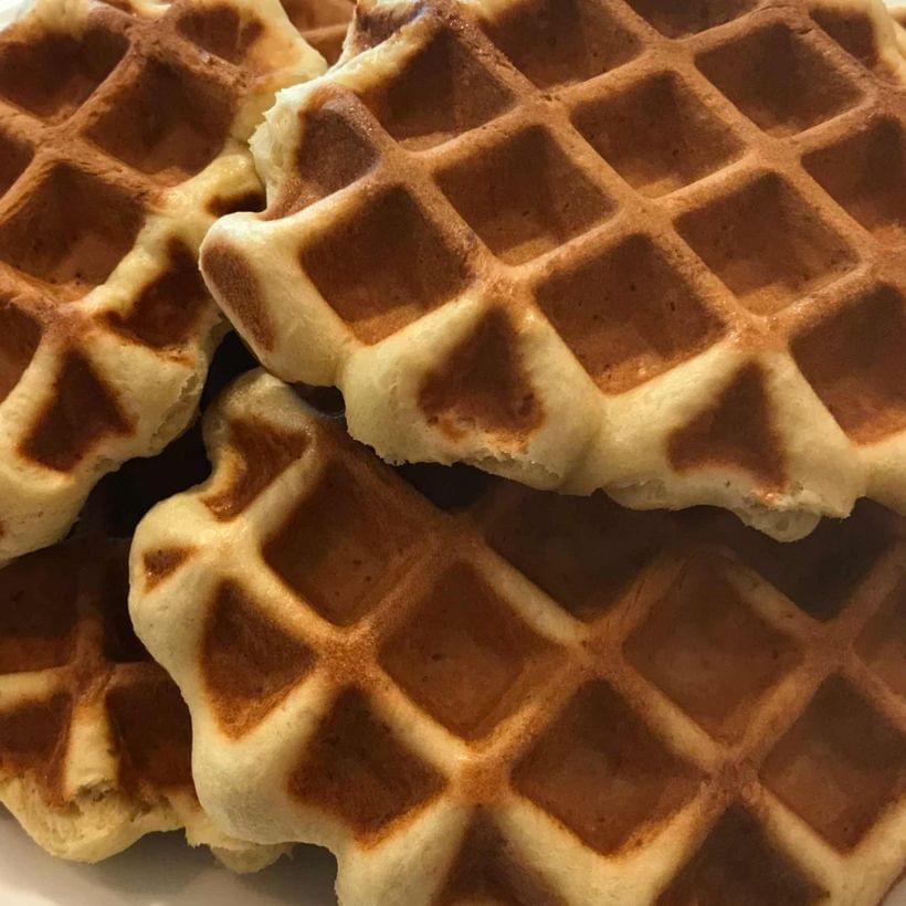 A stack of dark, chestnut brown waffles.